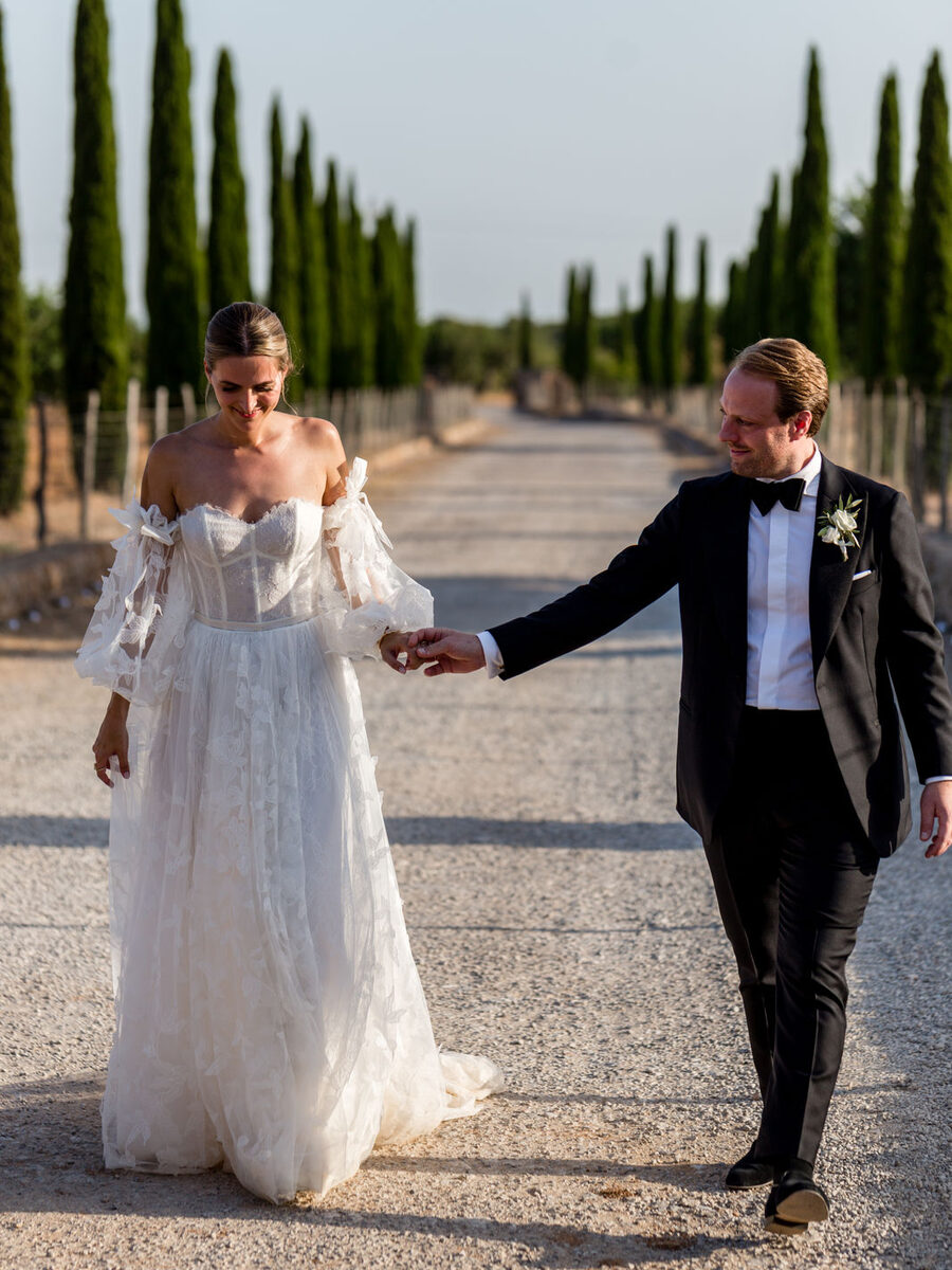 Destination Hochzeit Mallorca - Brautpaar Hand in Hand in der Zypressenallee