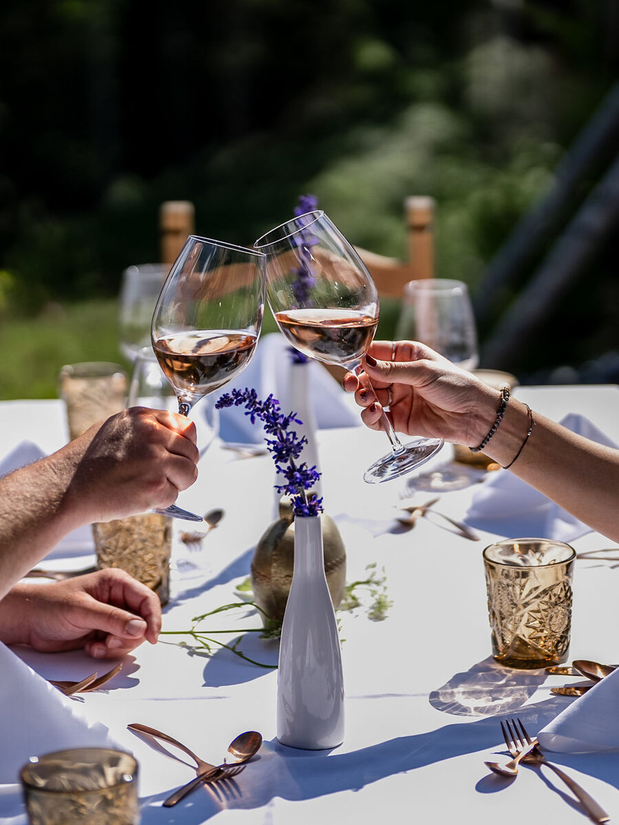 Destination Hochzeit Oesterreich - Anstossen mit Wein an der Tafel auf der Alm