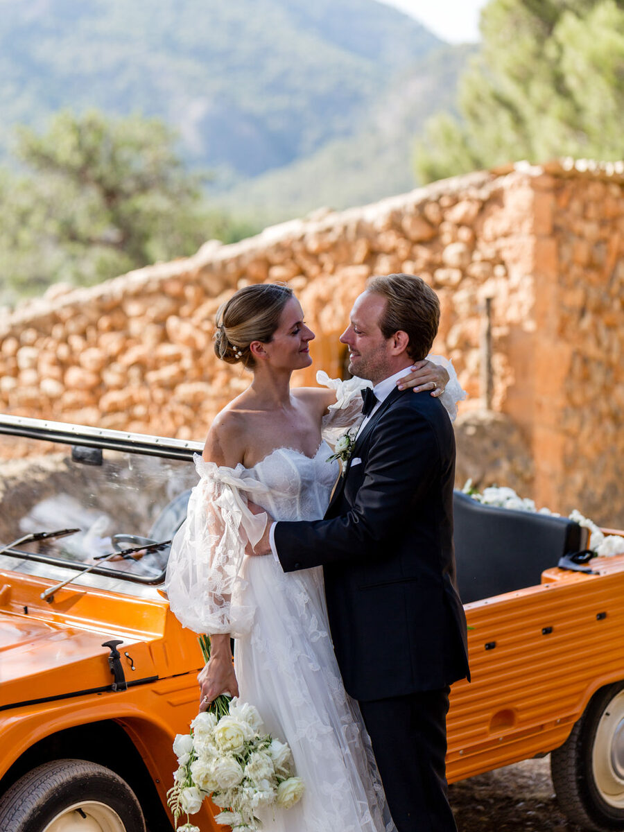 Destination Hochzeit Mallorca - Brautpaar an der Finca mit orangenem Oldtimer